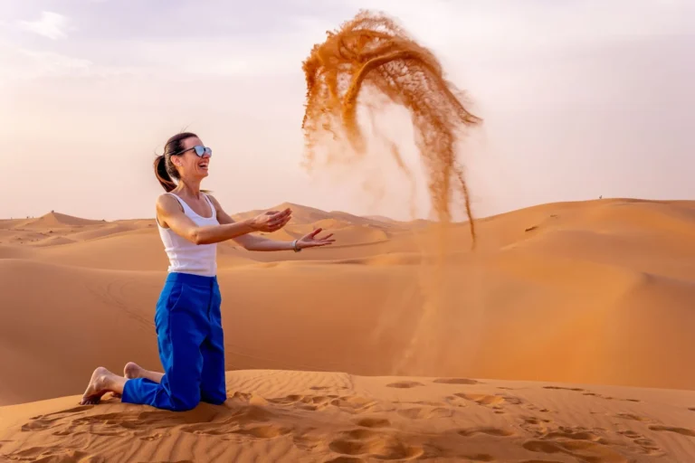 Girlplayingwithsandindesertsafari